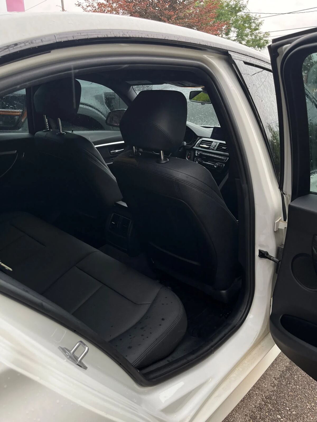 White BMW rear cabin freshly detailed — clean leather bench and door cards