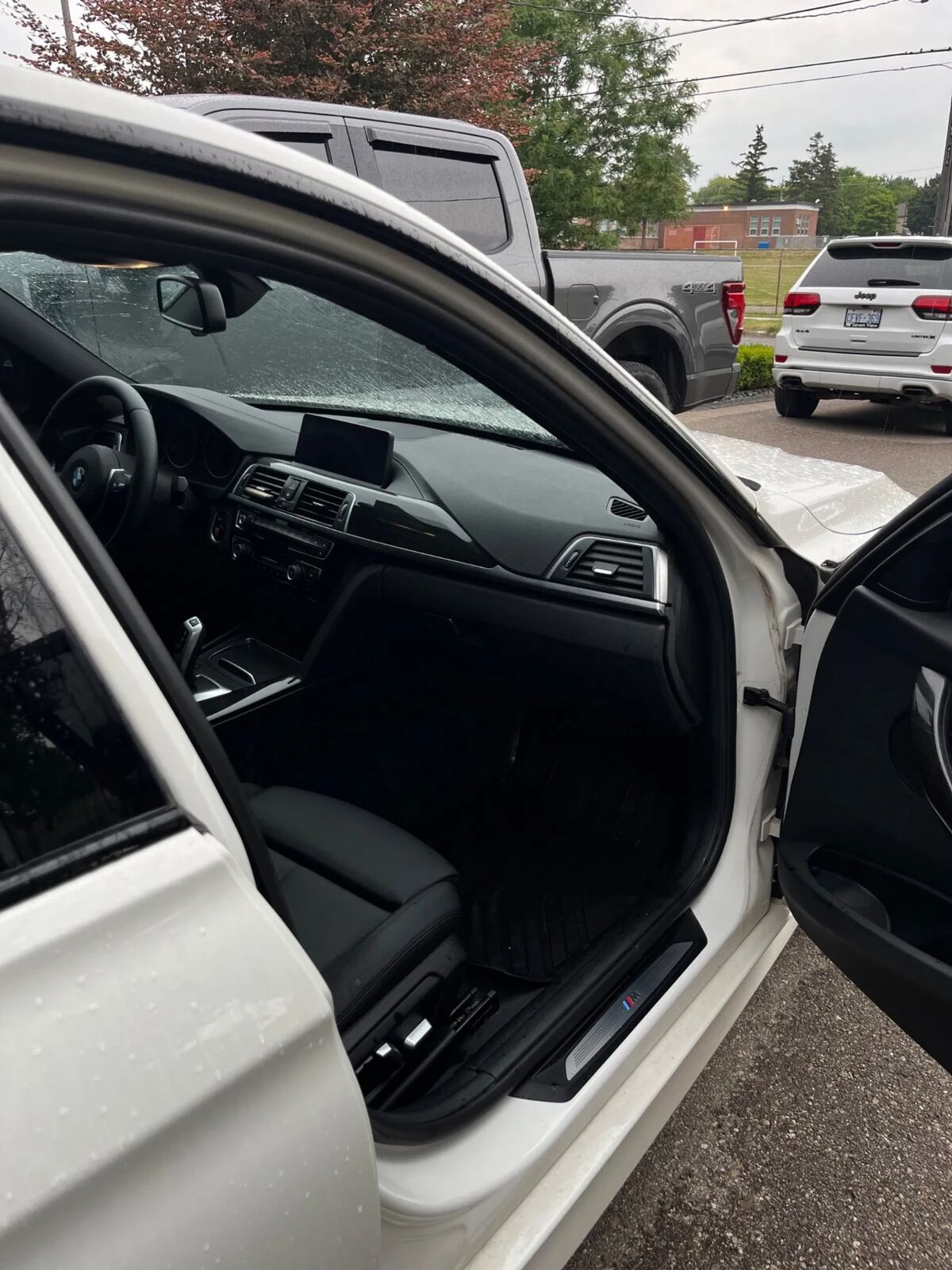 White BMW 3-Series driver side interior after CJ detail — spotless floor and door panels