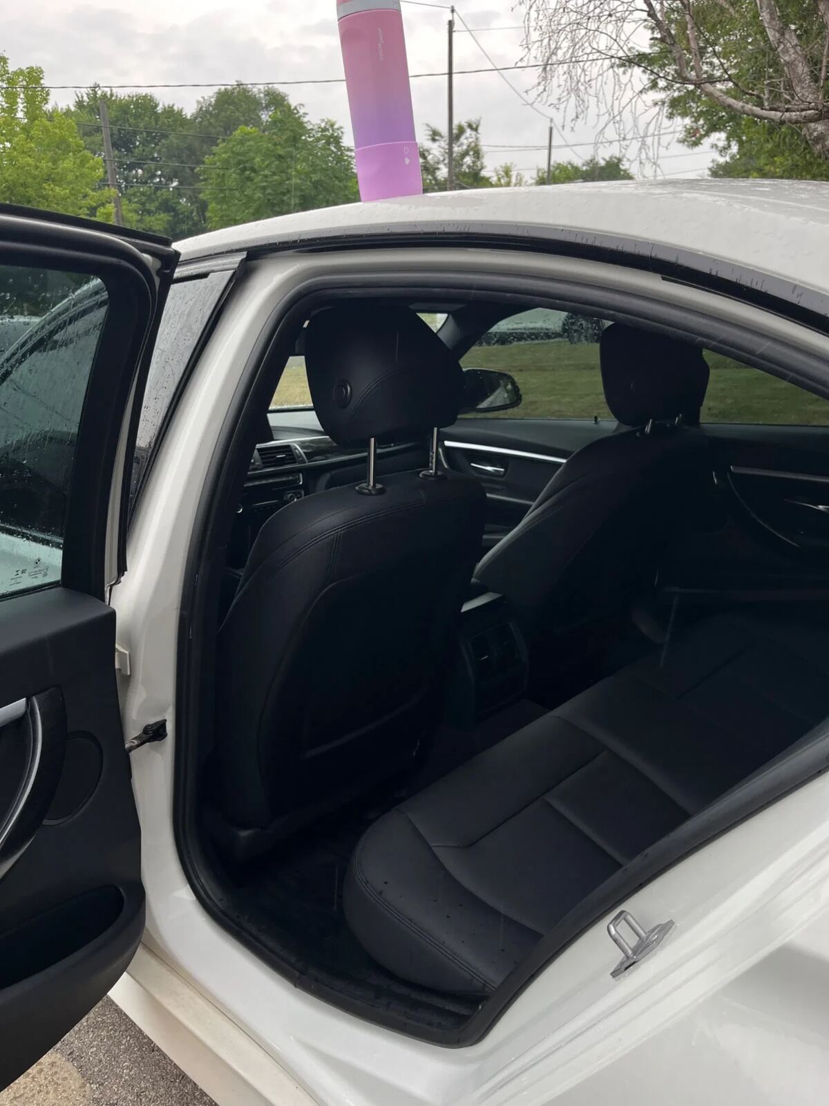 White BMW rear cabin from passenger side after detail — vacuumed carpets and clean seats